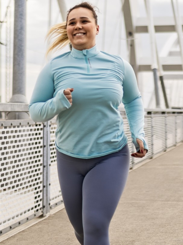 person jogging down the side path of a bridge